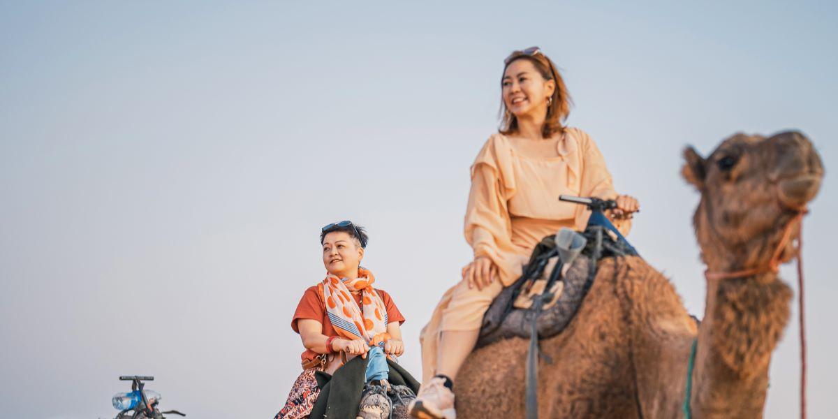 Twee vrouwen die kameel rijden in Marokko tijdens hun reis