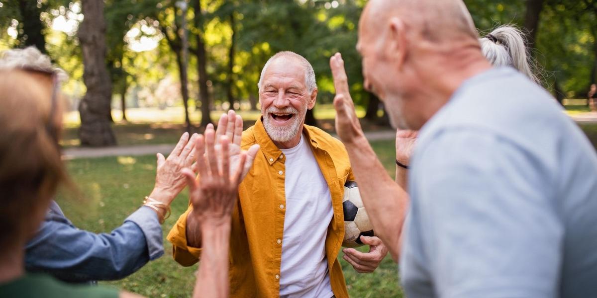 ouderen geven elkaar high fives in het park