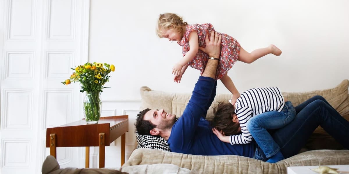Vader speelt met kinderen op de bank